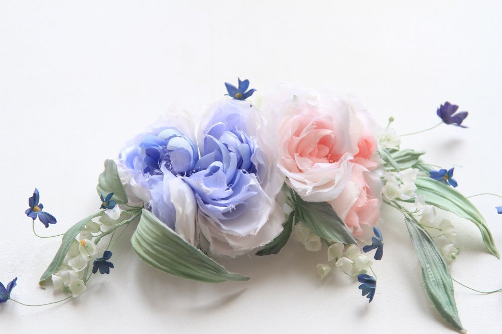 "Амелия"- необычайно утонченное украшение из натурального японского шелка, соединяющее в себе синюю и кораловую розы, ландыши и васильки. 