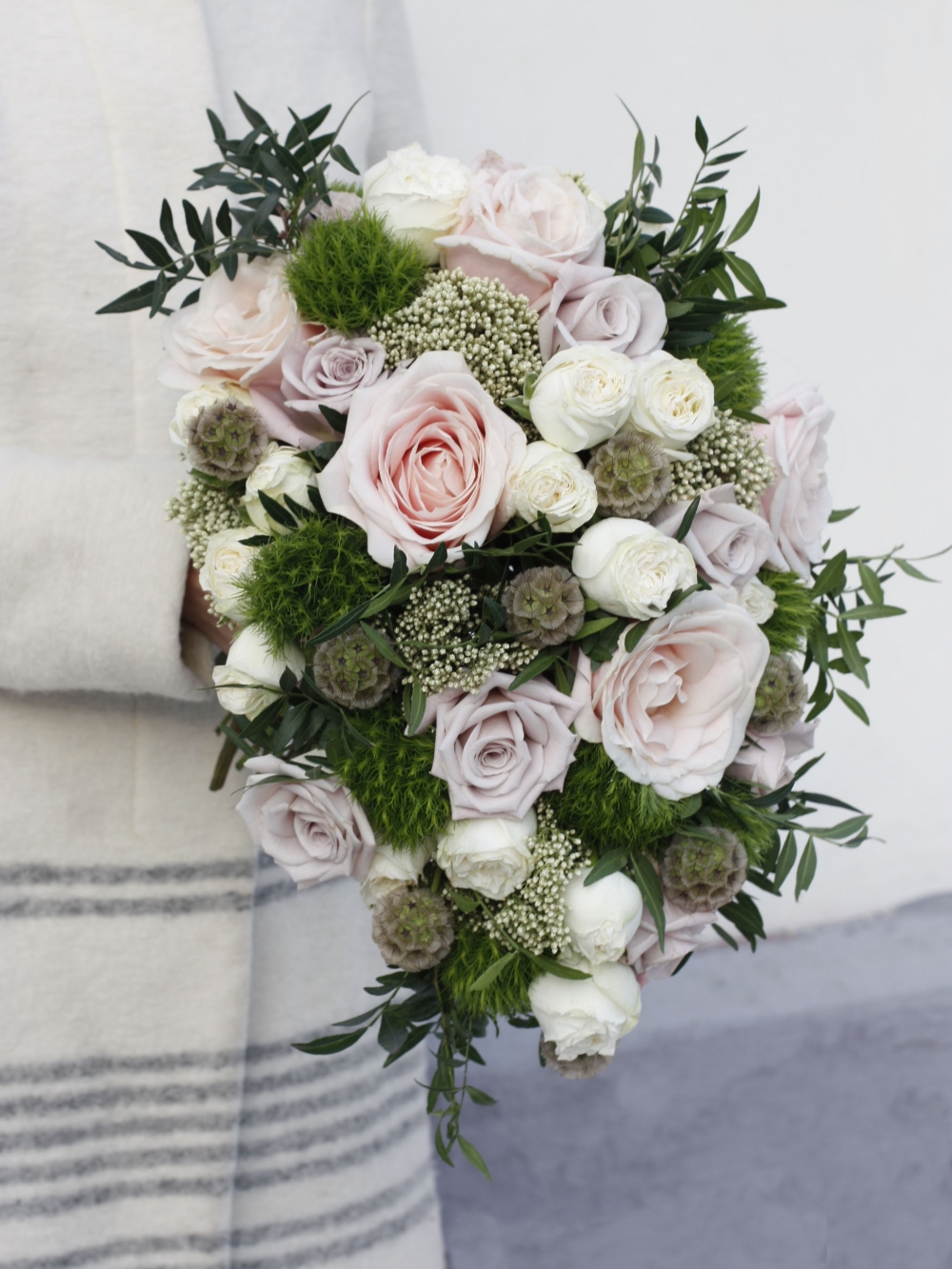 Каскадный свадебный букет на своих стеблях с трем сортами роз, пушистым зеленым диантусом, шариками скабиозы, озотамусом и зеленью