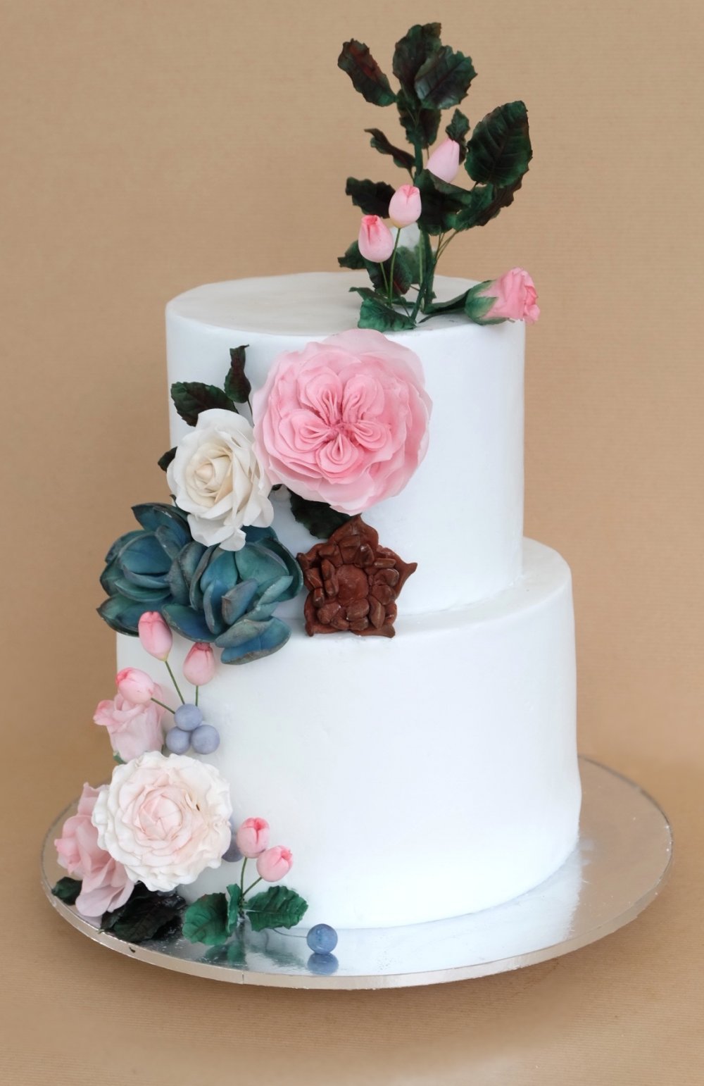 Белый двухъярусный торт с большой композицией из сахарной флористики. Бутоны роз, розы джульетты, каменные розы и ягодки.