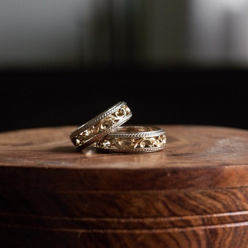 Два великолепных обручальных кольца из белого и желтого золота с изысканным природным орнаментом.