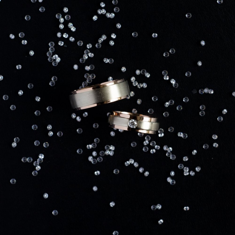 Обручальные кольца из комбинированного золота 585 пробы, женское кольцо украшает бриллиант весом 0,1 карат.