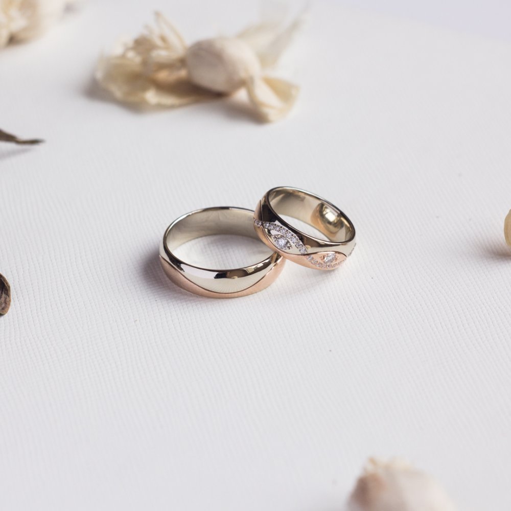 Обручальные кольца выполненные в классическом стиле из комбинированного золота 585 пробы, женское кольцо украшают 25 бриллиантов, общим весом 0,3 карата.
