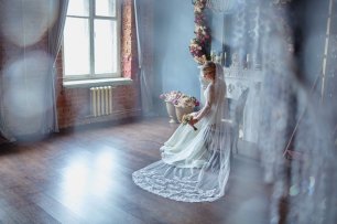 Невеста в студии оформленной цветочными композициями